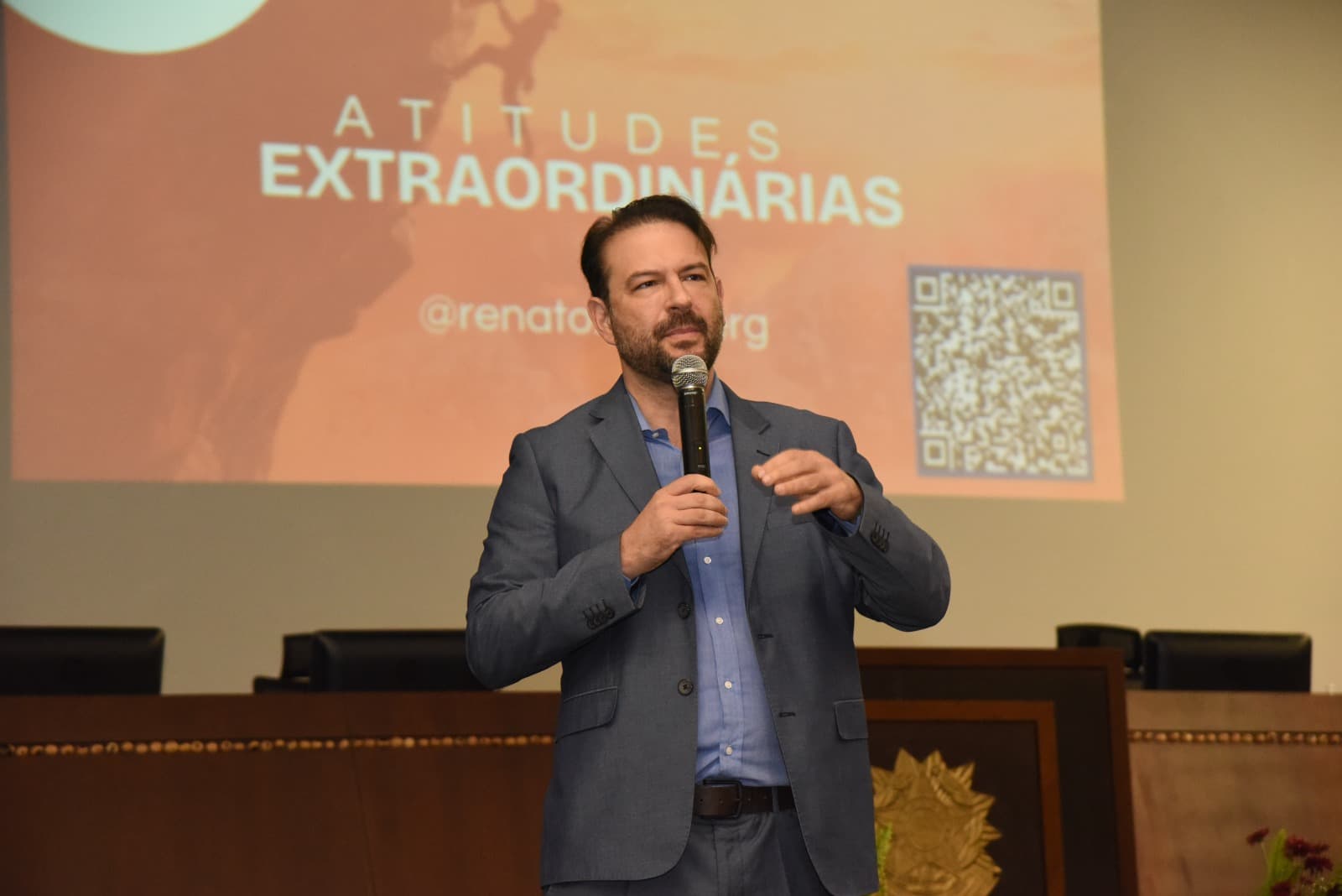 Auditório corporativo com público atento assistindo a palestra motivacional de Renato Grinberg