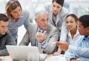 Profissionais de diferentes idades participando de um treinamento corporativo colaborativo